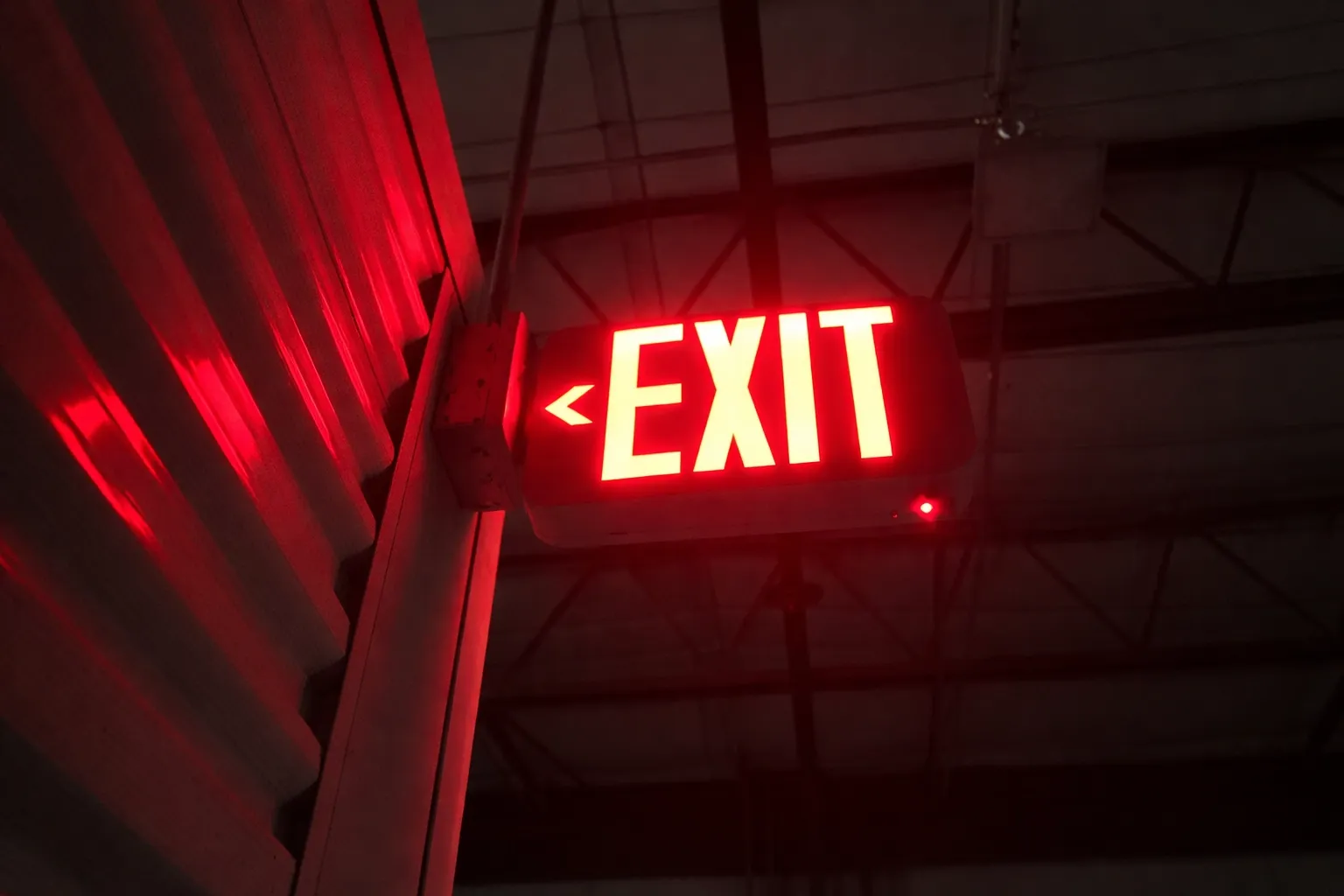 Illuminated exit sign inspected for visibility, power source, and path-of-travel compliance.
